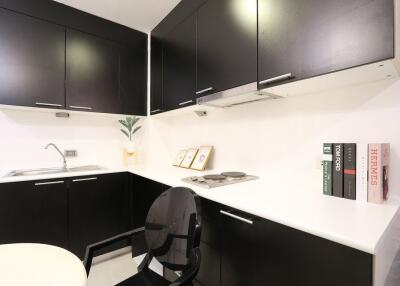 Modern compact kitchen with black cabinetry and white countertops