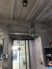 Industrial style interior with exposed piping and concrete ceiling