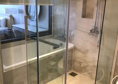 Modern bathroom with clear glass shower enclosure and visible bathtub