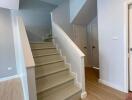 Modern staircase interior with light wooden floors and white stairs