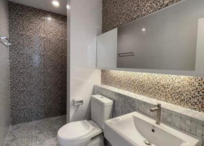 Modern bathroom with patterned tile walls and white fixtures