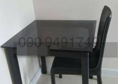 Compact black dining table with one chair in a kitchen area