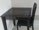 Compact black dining table with one chair in a kitchen area