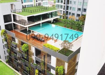 Aerial view of modern residential building with swimming pool and green spaces