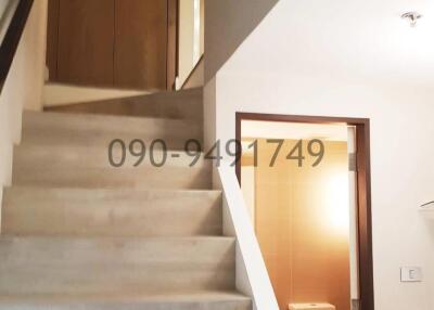 Modern staircase leading to the upper level with a visible bathroom