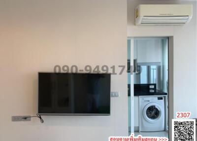 Modern living space with wall-mounted TV and adjacent washing area