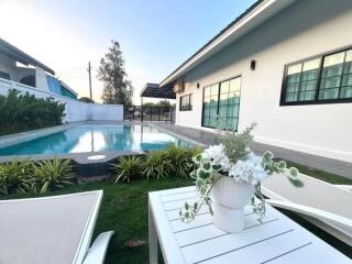 Luxurious poolside outdoor area with lush garden and modern home exterior