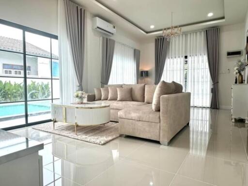 Elegant living room with plush sofa and pool view