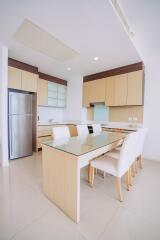 Modern kitchen with dining area featuring wooden cabinets and a large dining table