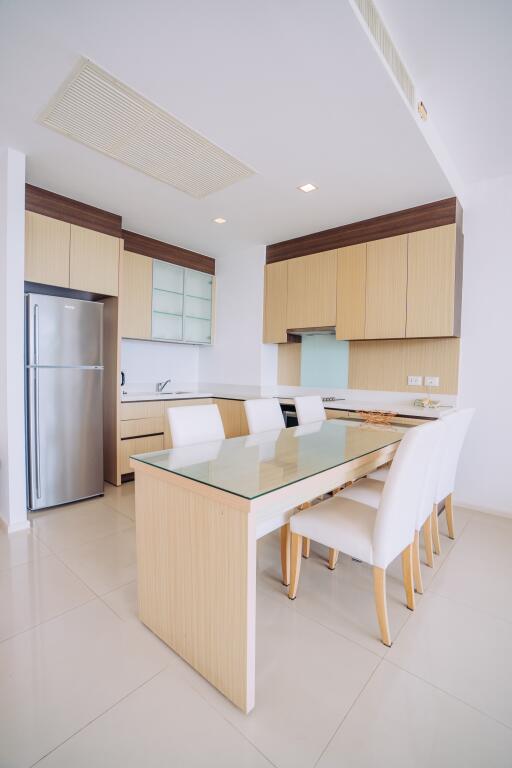 Modern kitchen with dining area featuring wooden cabinets and a large dining table