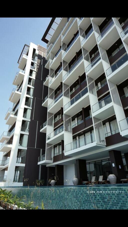 Modern high-rise residential building with balconies and a pool