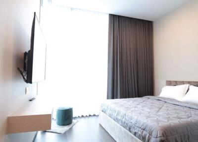 Modern bedroom with minimalistic design featuring large window and wall-mounted TV