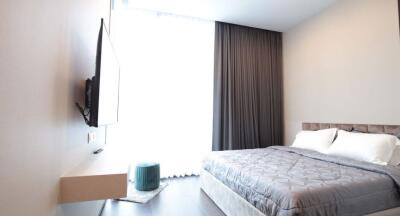 Modern bedroom with minimalistic design featuring large window and wall-mounted TV