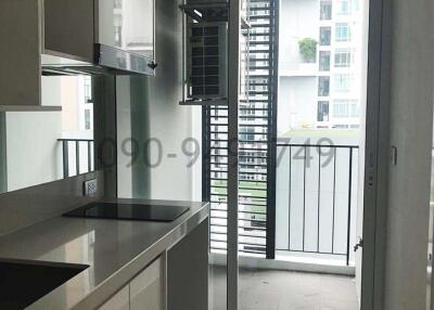 Modern kitchen with white cabinets and balcony access