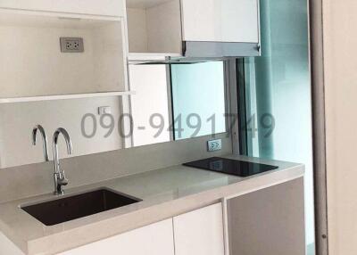 Modern kitchen with sleek white cabinetry and a glass door leading to another room