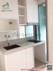 Modern kitchen with sleek white cabinetry and a glass door leading to another room