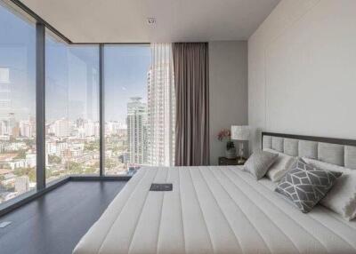 Modern bedroom with large windows and city skyline view