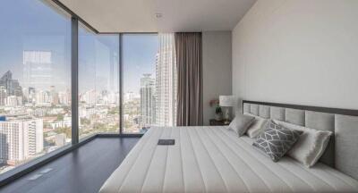 Modern bedroom with large windows and city skyline view