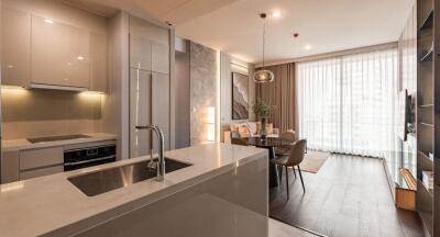 Modern kitchen with integrated dining space featuring sleek design and natural light