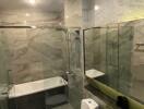 Modern bathroom with glass shower enclosure and marble walls