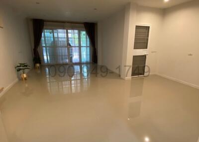 Spacious and bright unfurnished living room with large windows and glossy tiled flooring