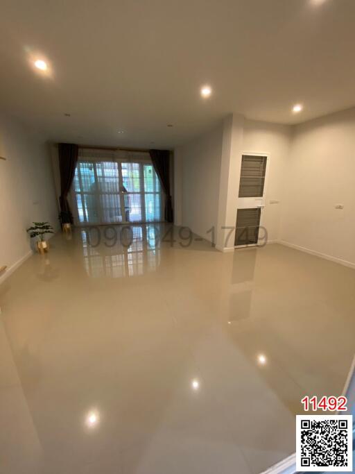 Spacious and bright unfurnished living room with large windows and glossy tiled flooring