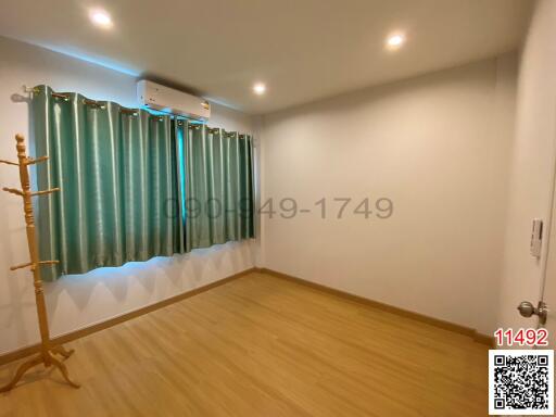 Spacious bedroom with wooden flooring and air conditioning