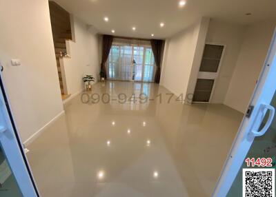Spacious and brightly lit living room with glossy tiled flooring