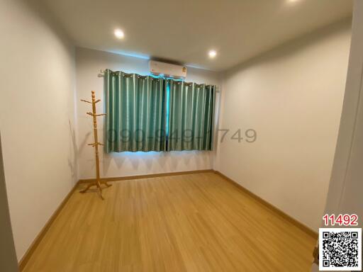 Spacious minimalist bedroom with wooden flooring and modern air conditioning