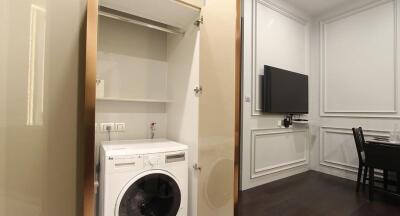 Modern laundry area with built-in appliances adjacent to dining room