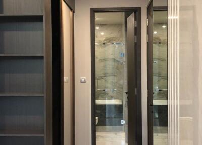 Modern interior design of a building hallway featuring glass doors and built-in shelves