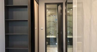 Modern interior design of a building hallway featuring glass doors and built-in shelves