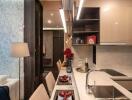 Modern kitchen with integrated dining area featuring marble countertops and sleek cabinetry