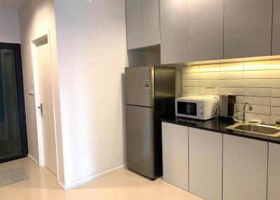 Modern kitchen interior with microwave, refrigerator, and clean design