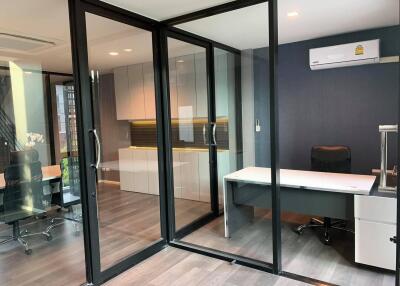 Modern office space with glass partition doors and wooden floors