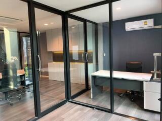 Modern office space with glass partition doors and wooden floors