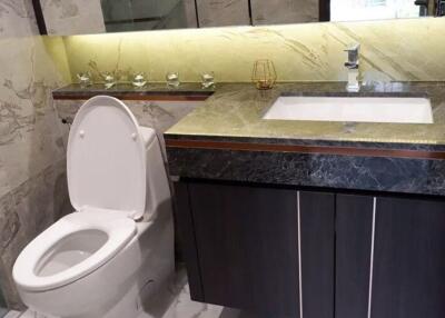 Modern bathroom with marble finish and elegantly lit mirror