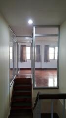 Bright and spacious hallway with reflective flooring and windows