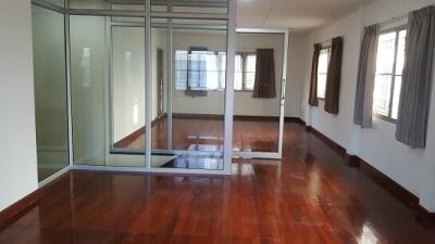 Spacious living room with wooden flooring and large windows