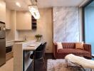 Modern compact living room with fully equipped kitchenette, stylish sofa and large window