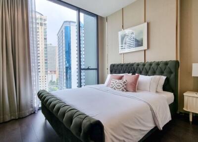 Modern bedroom with a city view through large windows