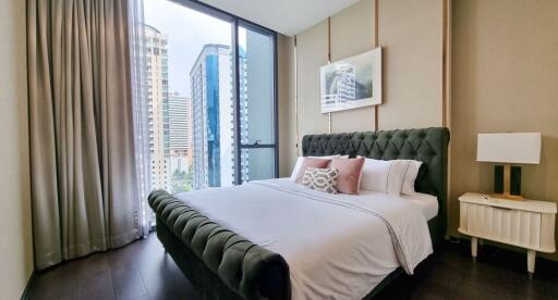 Modern bedroom with a city view through large windows