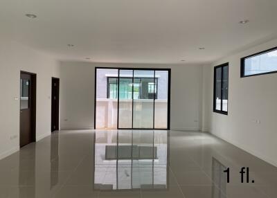 Spacious and bright empty living room with a reflective tile floor and large windows