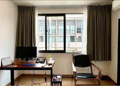 Home office with a desk, chair, and large windows