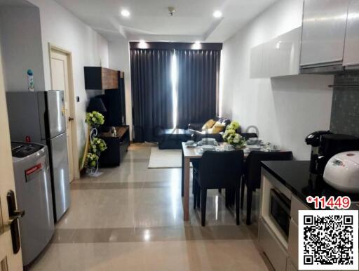 Modern open-plan living room with adjacent kitchen equipped with contemporary appliances