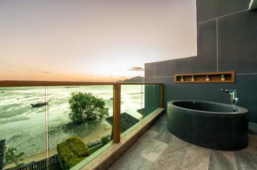 Luxurious balcony with freestanding bathtub overlooking a scenic coastal view