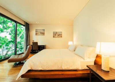 Spacious bedroom with large bed and view of the nature through glass doors
