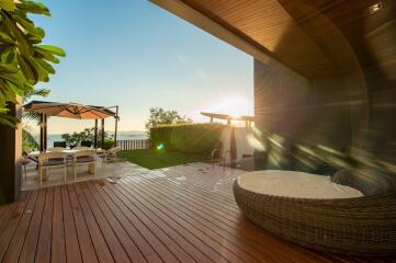 Spacious wooden deck patio with outdoor seating and ocean view at sunset