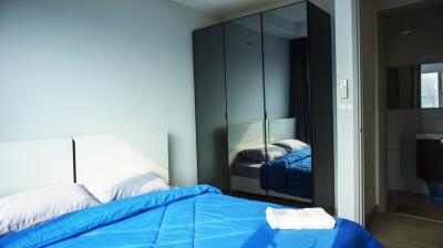 Modern bedroom with blue bedding and mirrored wardrobe