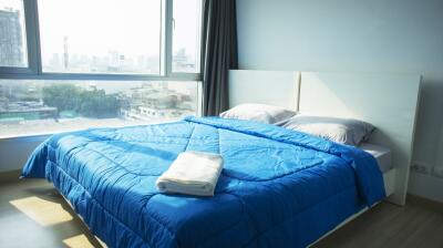 Modern bedroom with bright natural light and city skyline view